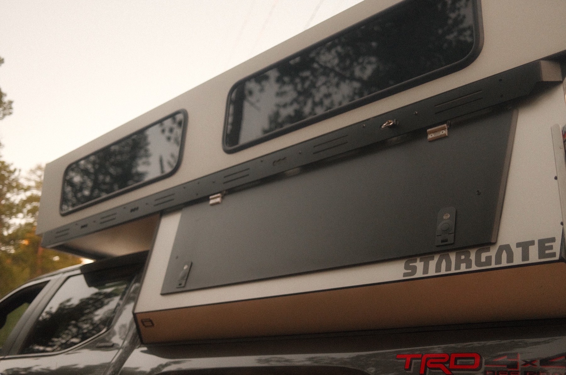 Radica STARGATE hard-sided pop-top raised on a Toyota truck, showing the upper shell sitting above the lower one